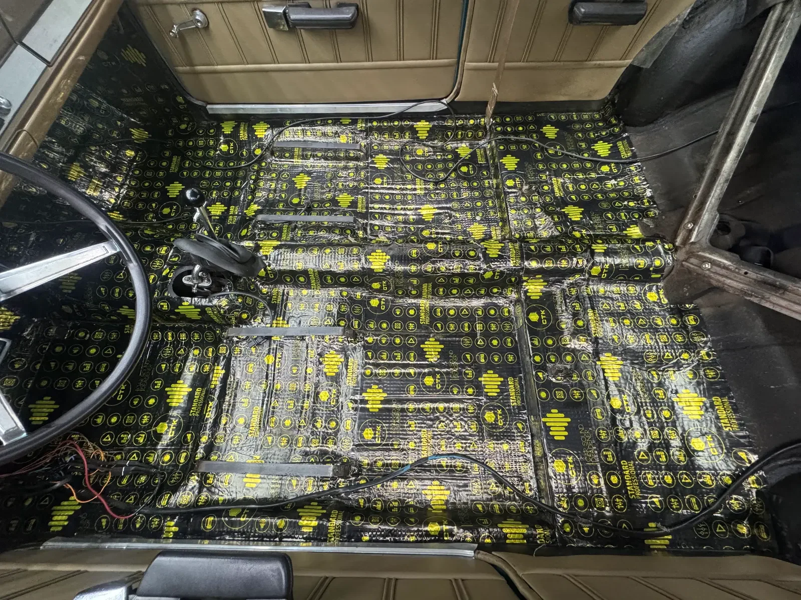 Piso del habitáculo de un auto desarmado, cubierto con láminas de material antivibratorio, en el taller de ADM TEAM
