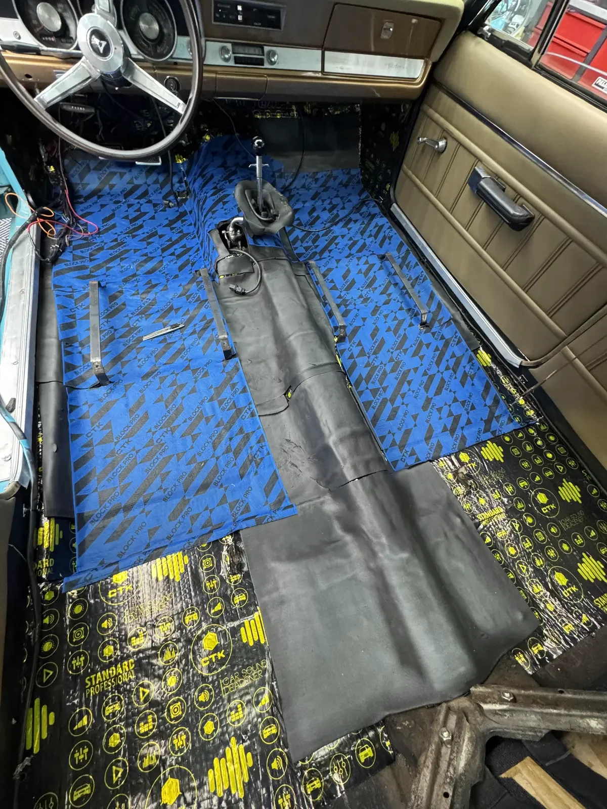 Segunda capa de espuma acústica sobre el antivibratorio del piso de un auto, en el taller de ADM TEAM