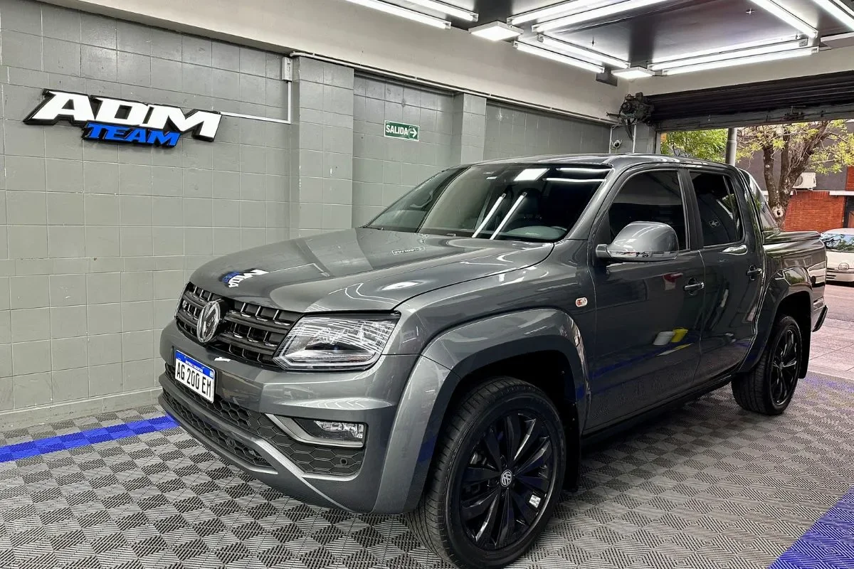 Volkswagen Amarok gris con PPF STEK en el taller de ADM TEAM, frente al logo del taller