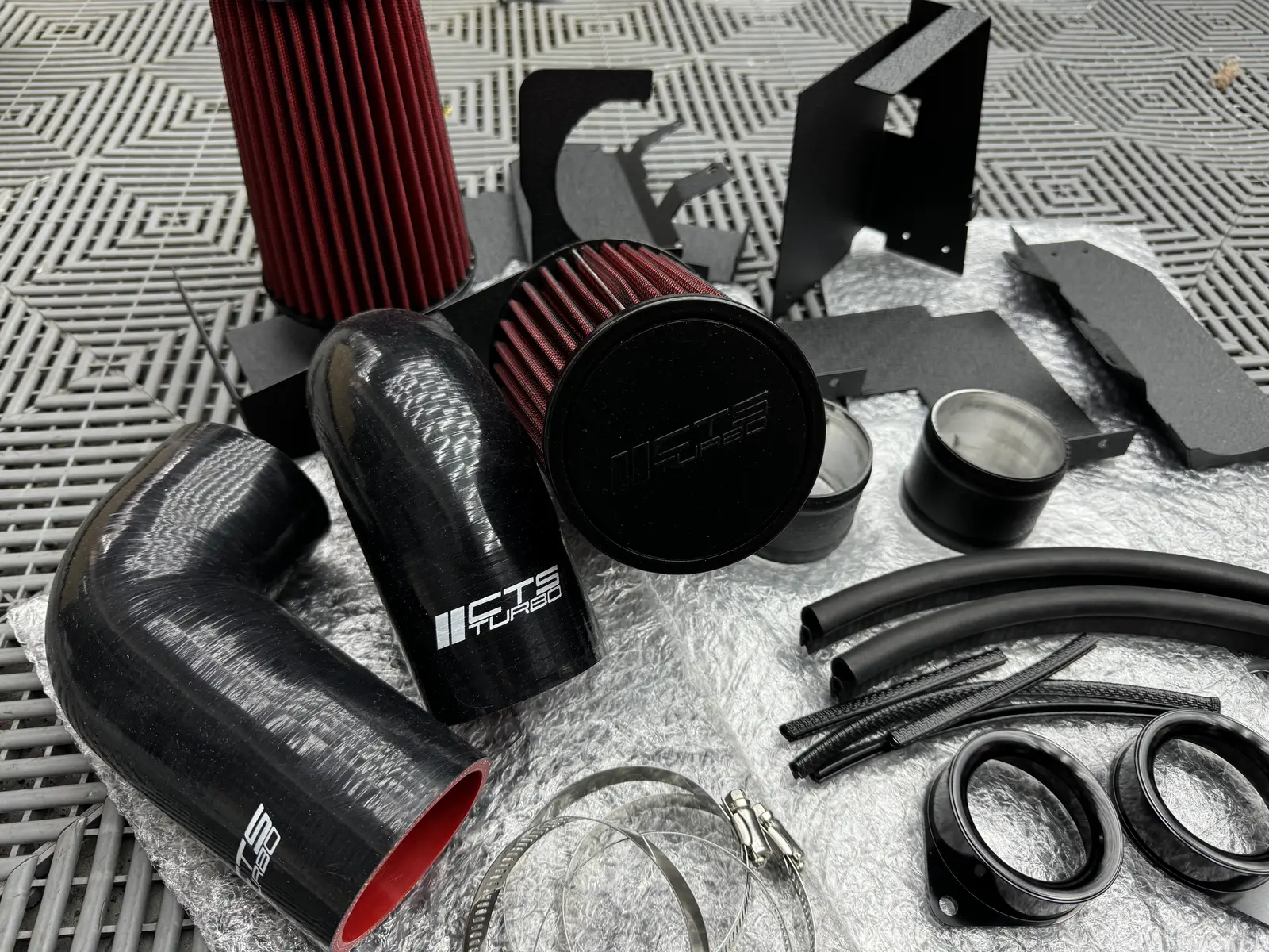 Kit de admisión desplegado antes del armado: filtro cónico, mangueras de silicona, abrazaderas y soportes