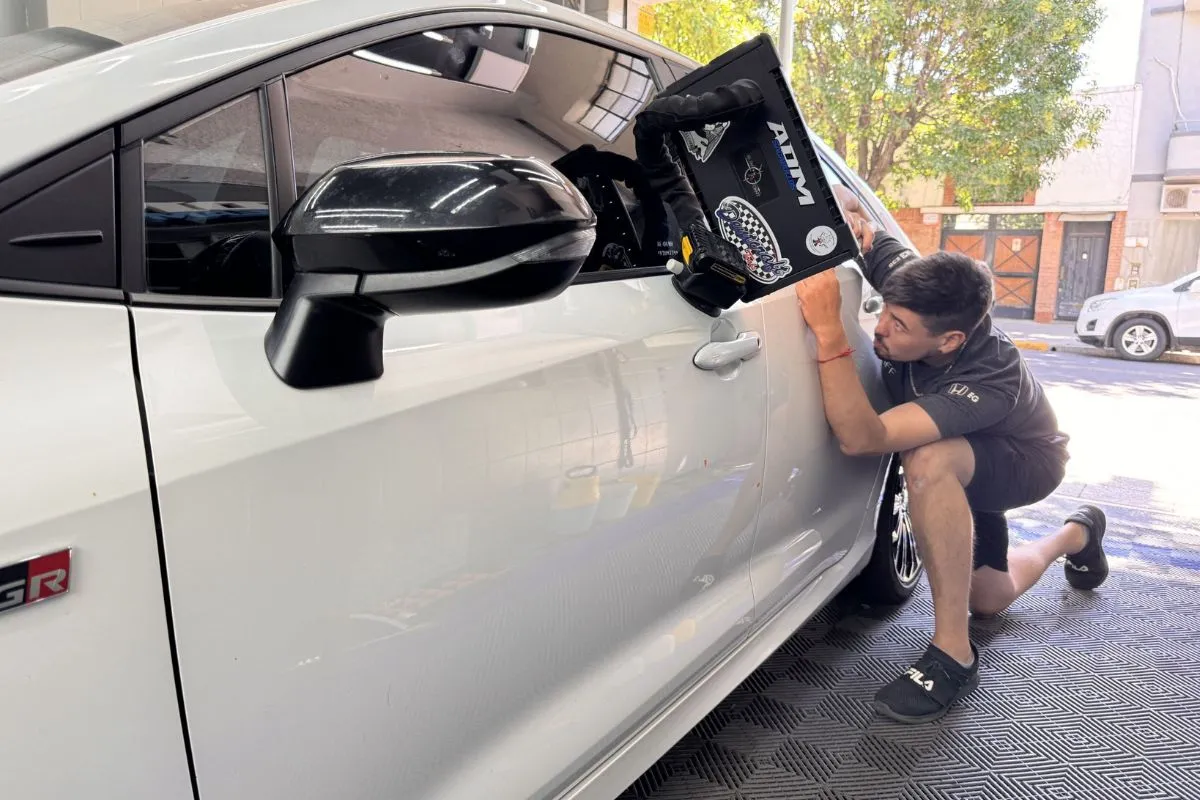 Técnico reparando una abolladura sin pintar con la técnica PDR